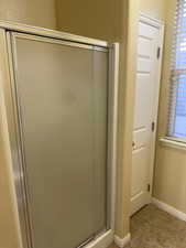 Full bathroom featuring a stall shower, tile patterned floors, and plenty of natural light