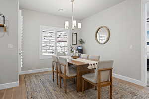 Dining space with light wood-style floors and a chandelier