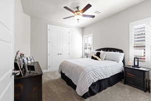 Bedroom with carpet, a closet, and a ceiling fan
