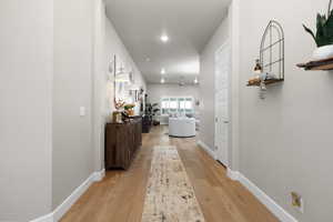 Corridor featuring light wood-style floors and recessed lighting