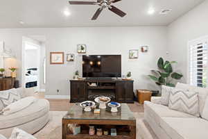 Living area with a ceiling fan, light wood-style floors, and recessed lighting