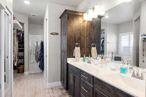 Full bath with double vanity and a walk in closet