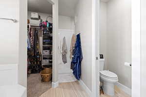 Full bath featuring a walk in closet and wood finished floors