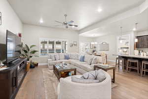 Living area featuring ceiling fan, light wood-style flooring, a chandelier, and recessed lighting