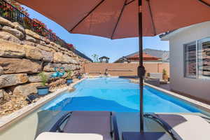 View of pool with a fenced backyard and a pool with connected hot tub