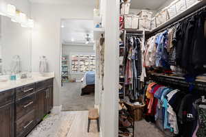 Walk in closet with ceiling fan and a sink