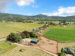 Aerial view of sparsely populated area featuring property parcel outlined and a mountain backdrop