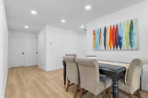 Dining space with light wood-style flooring and recessed lighting