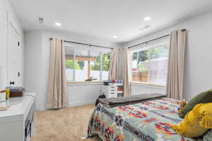 Bedroom featuring light carpet and recessed lighting