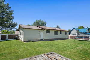Back of property featuring a trampoline, a fenced backyard, and a metal roof