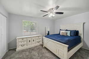 Bedroom with dark colored carpet and ceiling fan
