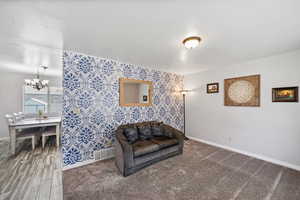 Sitting room featuring wallpapered walls and a chandelier