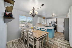 Dining area with a chandelier and light wood-style flooring