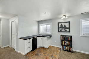 Kitchen with dark countertops, refrigerator, a textured ceiling, white cabinets, and an office area