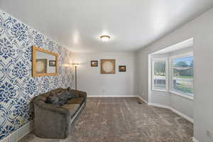 Living area with wallpapered walls and carpet floors