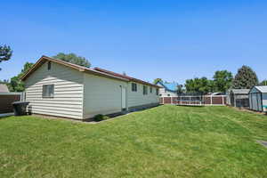 View of yard with a trampoline and an outbuilding