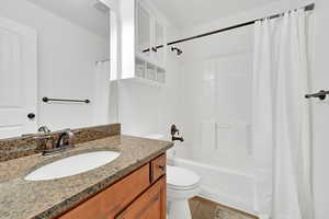 Full bathroom with granite countertop, newer faucets  and shower head on tub, shower and sink.