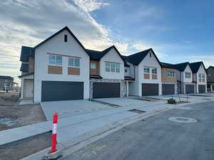 View of front of property featuring a residential view, a garage, and concrete driveway