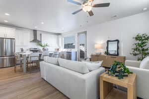 Living area featuring light wood-style flooring, ceiling fan, and recessed lighting