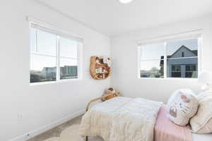 Carpeted bedroom featuring multiple windows
