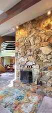 Great room with vaulted ceilings, a fireplace, and view of kitchen