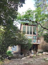 East side of property featuring a wooden deck and brick siding