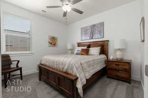 Carpeted bedroom featuring baseboards and a ceiling fan