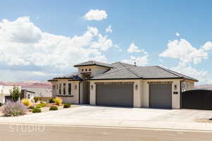 View of front of house featuring a garage, concrete driveway, stucco siding, a tiled roof, and a gate