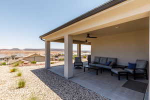 Fenced backyard with an outdoor hangout area, a patio area, ceiling fan, and a mountain view