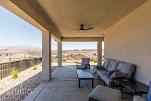 Fenced backyard featuring an outdoor hangout area, a mountain view, ceiling fan, and a patio