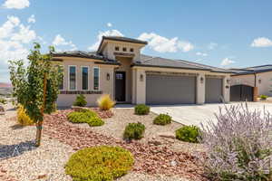 View of front facade with a garage, concrete driveway, stucco siding, a gate, and a tiled roof