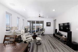 Living room with light wood-style floors, a ceiling fan, and recessed lighting