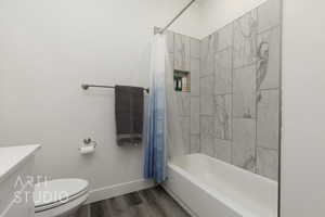 Bathroom featuring wood finished floors, shower / tub combo, and vanity
