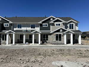 View of front facade featuring stone siding, board and batten siding, and a porch