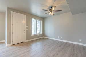 Foyer featuring a textured ceiling, light wood-style floors, and a ceiling fan
