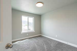 Carpeted spare room with a mountain view and baseboards