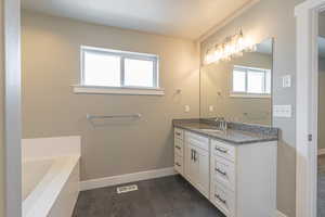 Bathroom featuring vanity and a tub to relax in