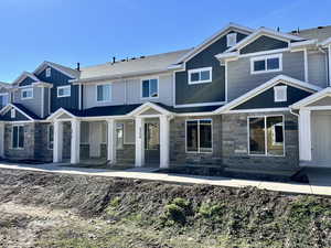 Craftsman-style home featuring board and batten siding, stone siding, and covered porch