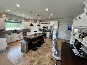 Kitchen with appliances with stainless steel finishes, tasteful backsplash, a center island, a breakfast bar area, and a textured ceiling