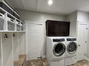 Washroom featuring washer and clothes dryer and cabinet space