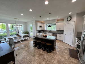 Kitchen with appliances with stainless steel finishes, a center island, decorative backsplash, recessed lighting, and white cabinets
