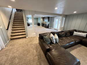 Carpeted living room featuring stairs, recessed lighting, and healthy amount of natural light
