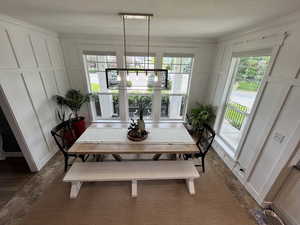 Dining room with a decorative wall, healthy amount of natural light, dark wood-style floors, and a textured ceiling