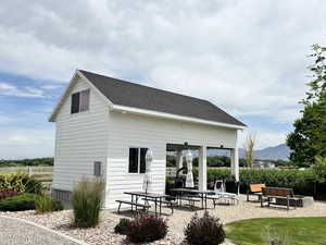 Back of property with a mountain view, a patio area, and a shingled roof