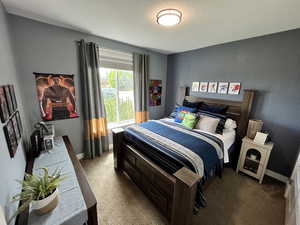 Carpeted bedroom featuring a textured ceiling and baseboards
