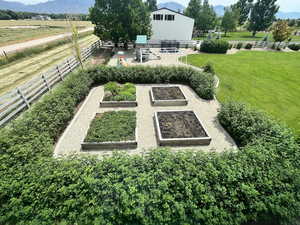 View of yard featuring a vegetable garden, a mountain view, and a view of countryside