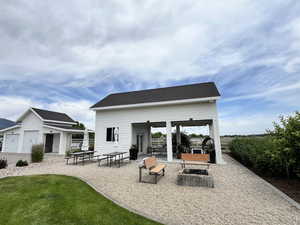 View of patio / terrace featuring an outdoor fire pit and an outdoor structure