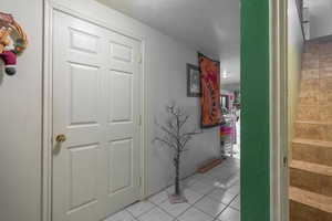 Hall featuring light tile patterned flooring