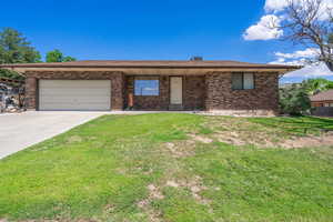 Ranch-style house with brick siding, a garage, concrete driveway, and a front lawn
