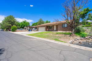 Ranch-style home featuring driveway, a garage, and brick siding